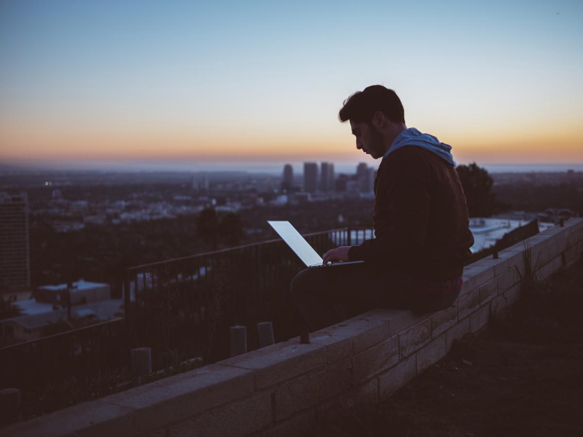 Image depicting a person working on a laptop and an open laptop with dollar signs emerging from it, symbolizing success in online freelancing.